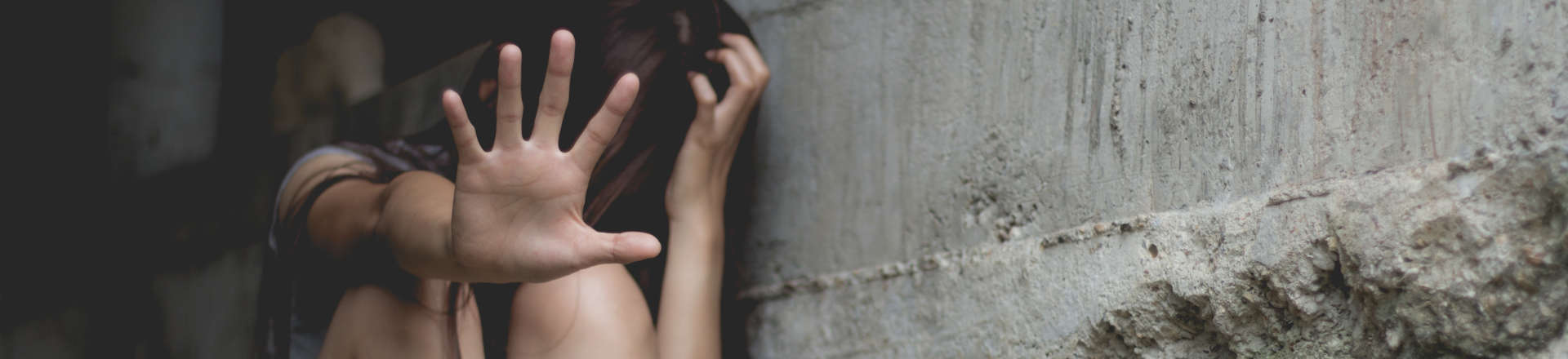 a terrified woman covering her face