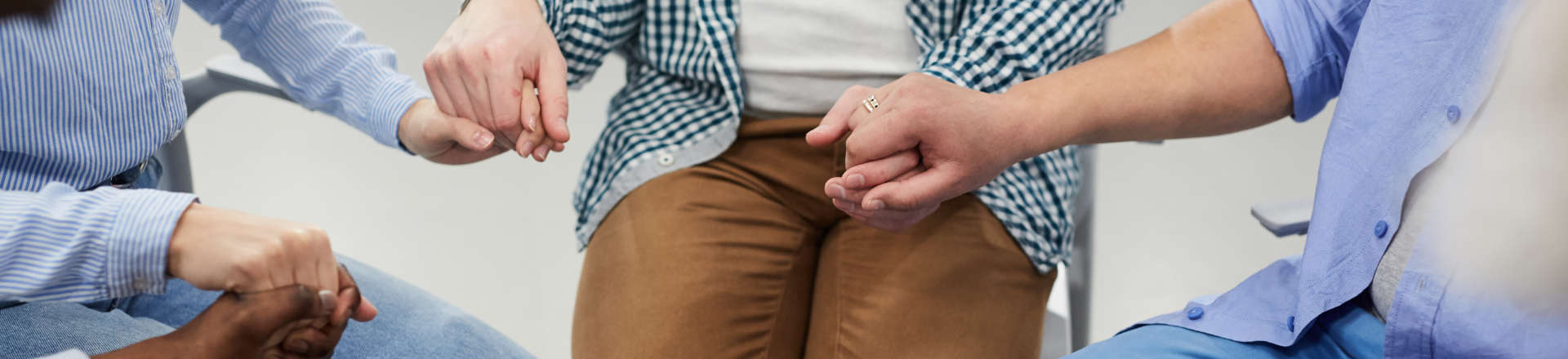 group of people sitting in a circle and holding each other's hands