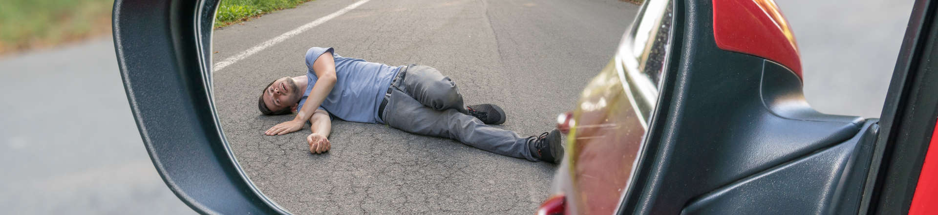 a man hit by a car lying on the road