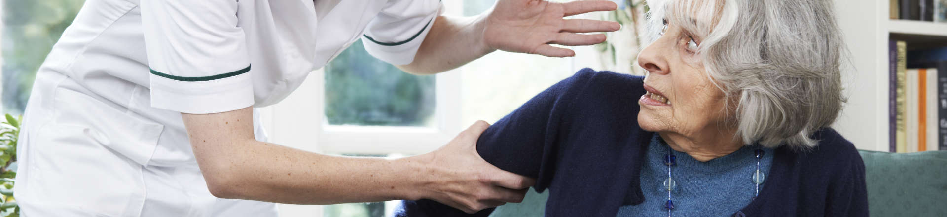 a nurse shouting at a terrified elderly woman