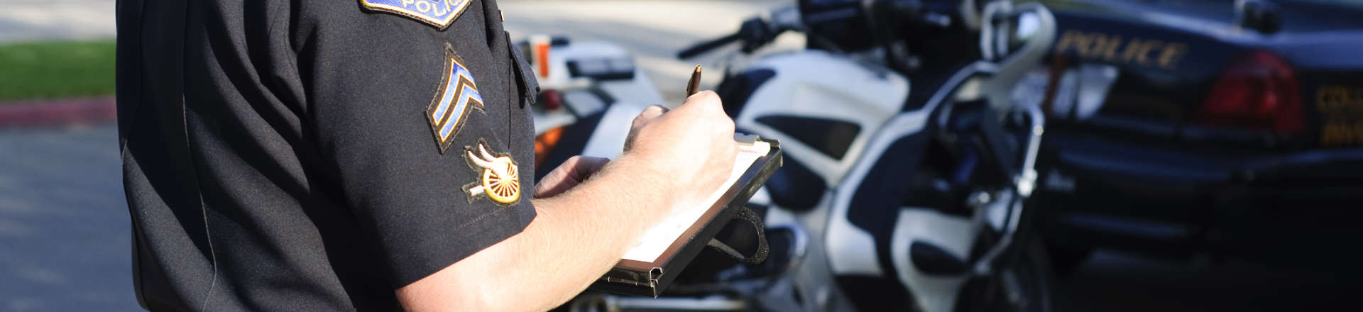 a police officer taking notes after a traffic accident involving a motorist