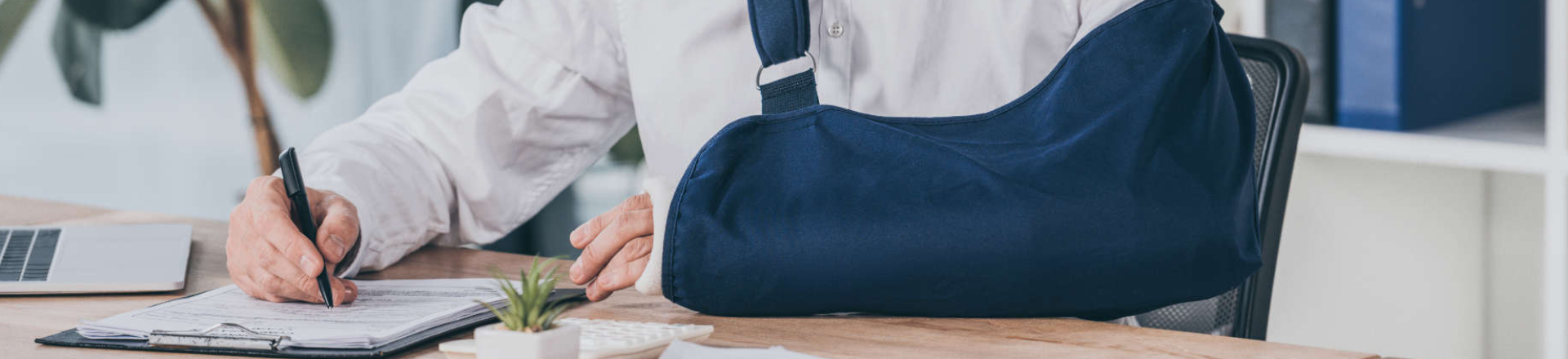a person with a broken arm signing documents