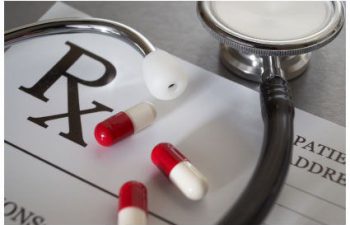 medicines, a stethoscope and a blank prescription