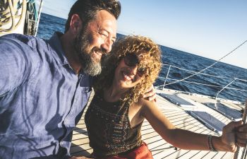 Happy middle-aged couple enjoying boating on a sunny day.