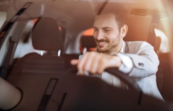 Handsome businessman driving car before buying